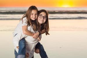 portrait de deux jeunes soeurs sur la plage. photo