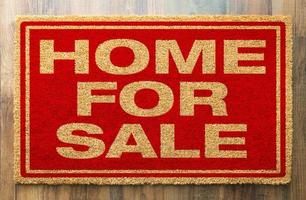 maison à vendre tapis de bienvenue sur un fond de plancher en bois photo