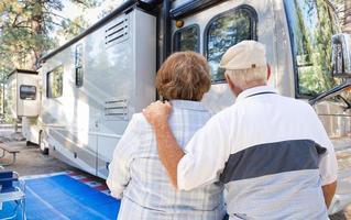 couple de personnes âgées regardant un beau camping-car au camping. photo