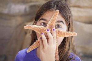 jeune fille jouant avec des étoiles de mer photo