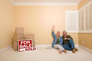 couple sur le sol près des boîtes et des enseignes immobilières vendues photo