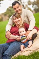 Happy mixed race family posant pour un portrait dans le parc photo