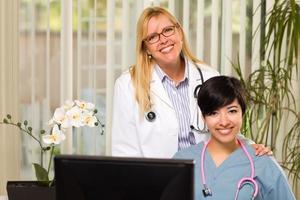 smiling mixed race femmes médecins ou infirmières en milieu de bureau photo