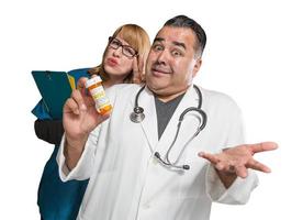 docteur maladroit et infirmière avec bouteille de prescription isolé sur fond blanc. photo