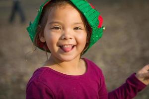 mignon métis jeune fille s'amusant portant un chapeau de noël à l'extérieur photo