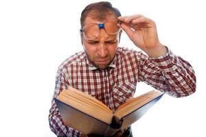 homme geek avec une mauvaise vue essayer de lire un livre photo