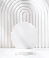 une scène minimaliste d'un podium en gypse avec des pierres sur fond blanc, pour les cosmétiques naturels photo