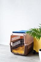 transporteur pour animaux de compagnie en plastique ou cage pour animaux de compagnie avec étui de voyage jaune sur le sol à la maison, coin pour animaux de compagnie transporteur pour animaux de compagnie en plastique ou cage pour animaux de compagnie avec étui de voyage jaune sur le sol à la maison, coin pour animaux de compagnie photo