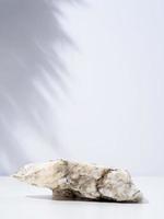 une scène minimaliste de podium en marbre de pierre sur fond blanc, pour les cosmétiques naturels photo