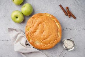 tarte aux pommes charlotte sur table en béton avec pomme fraîche et cannelle , vue d'en haut photo