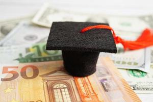 chapeau d'écart de graduation sur l'argent des billets en euros et en dollars américains, frais d'étude de l'éducation apprentissage enseigner le concept. photo
