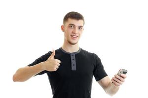 portrait d'un jeune homme gai dans un t-shirt qui montre la classe et tient dans sa main une tondeuse à raser photo