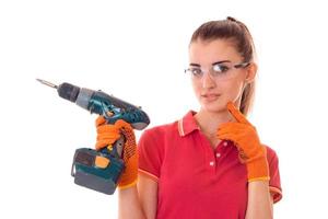 jeune fille dans des lunettes de protection transparentes tenant une perceuse close-up isolé sur fond blanc photo