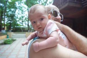 mignon petit bébé dans les bras de papa photo