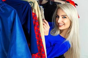 charmante jeune fille blonde souriante dans un magasin de vêtements photo