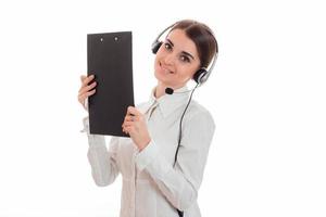 Jeune jolie fille de bureau d'appel en chemise blanche avec casque et tablette isolé sur fond en studio photo