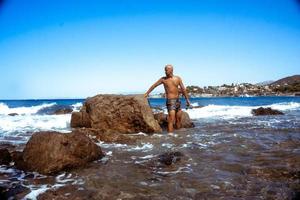 bel homme sur le rivage rocheux marin photo