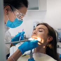 dentiste traite les dents d'une belle patiente photo