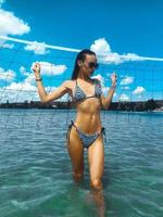 Slim jeune brune en maillot de bain rayures et lunettes de soleil photo