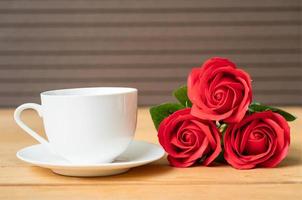 rose rouge et tasse de café sur bois photo