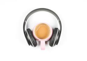 mise à plat d'une tasse de café rose recouverte d'un casque sur fond blanc. concept de temps de détente de musique et de café. photo