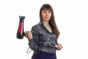 styliste femme avec un sèche-cheveux et un peigne dans les mains photo