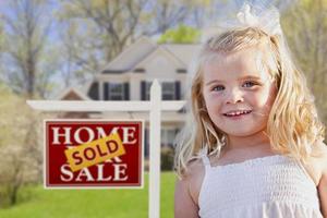 jolie fille dans la cour avec maison et signe immobilier vendu à vendre photo