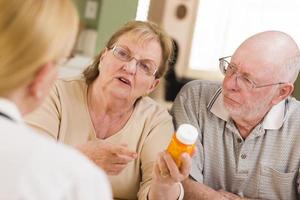 médecin ou infirmière expliquant les médicaments sur ordonnance à un couple de personnes âgées photo