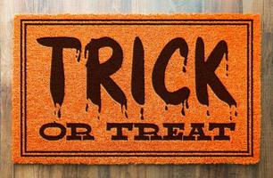 Trick or Treat halloween tapis de bienvenue orange sur fond de plancher en bois photo