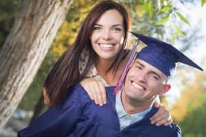 Diplômé masculin en bonnet et robe et fille célébrer photo