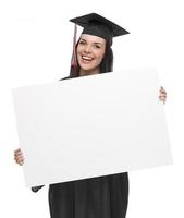 femme diplômée en bonnet et robe tenant une pancarte blanche photo