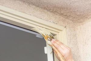 peintre professionnel coupant avec un pinceau pour peindre le cadre de la porte de la maison. photo