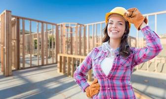 jeune ouvrière du bâtiment séduisante portant des gants, un casque et des lunettes de protection sur le chantier photo