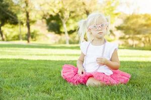 petite fille jouant à s'habiller avec des lunettes roses et un collier photo