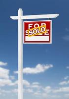 face à droite vendu à vendre signe immobilier sur un ciel bleu avec des nuages. photo