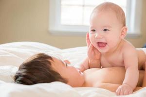 Métis chinois et caucasiens bébés frères s'amusant allongés sur leur couverture photo