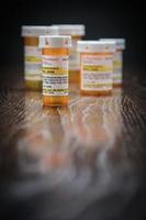 variété de flacons de médicaments sur ordonnance non exclusifs sur une surface en bois réfléchissante. photo