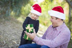 père donnant à sa jeune fille un cadeau de noël photo