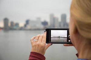 femme prenant des photos de la ligne d'horizon de la nouvelle orléans avec son téléphone intelligent
