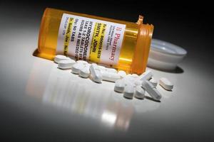 pilules d'hydrocodone et bouteille de prescription avec étiquette non exclusive. aucune autorisation de modèle requise - contient des informations fictives. photo