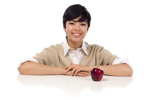 Smiling mixed race young adult female sitting with apple photo