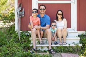 portrait d'un couple caucasien et chinois avec leurs jeunes garçons métis portant des lunettes de soleil photo