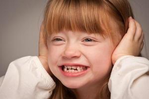 portrait amusant d'une adorable fille aux cheveux rouges sur gris photo