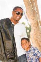heureux père afro-américain et fils métis jouant au parc photo