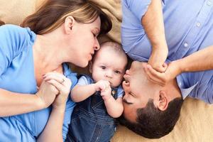 famille métisse avec bébé jouant sur la couverture photo