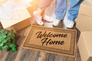 homme et femme déballant près de la maison de bienvenue tapis de bienvenue, cartons de déménagement et plante photo