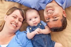 jeune couple métis portant avec leur bébé sur une couverture photo