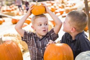 deux garçons au champ de citrouilles parlant et s'amusant photo