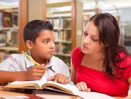 mère et fils hispaniques étudiant à la bibliothèque photo