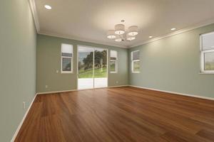 pièce de maison récemment rénovée avec planchers de bois finis, moulures, peinture vert clair et plafonniers. photo
